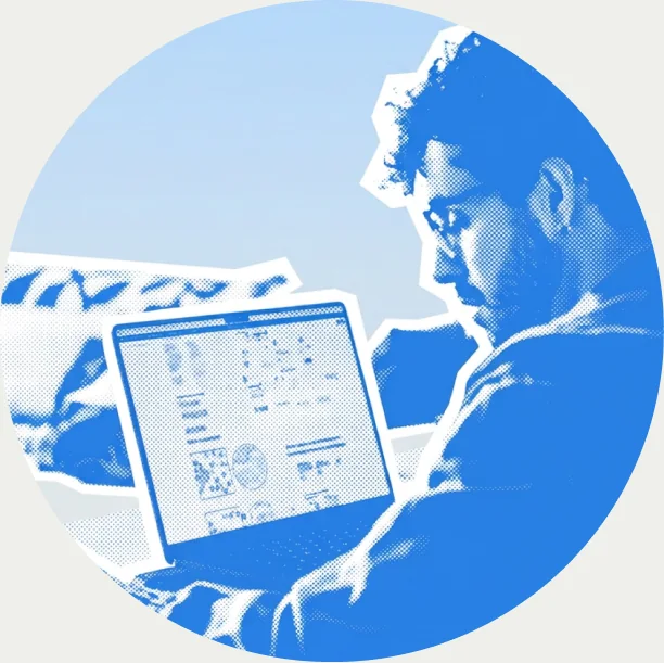 Guilherme reviewing a layout on a laptop, in a blue duotone portrait.