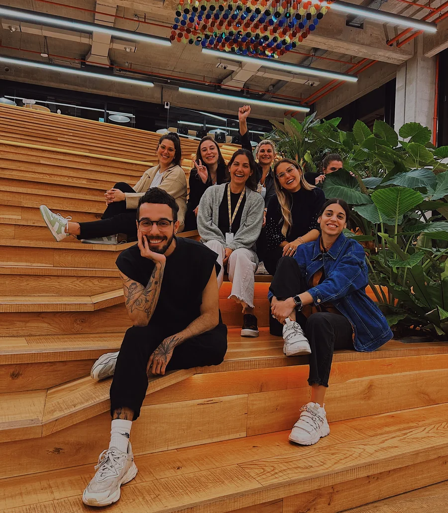 Guilherme sitting on wide wooden steps with a group of colleagues.